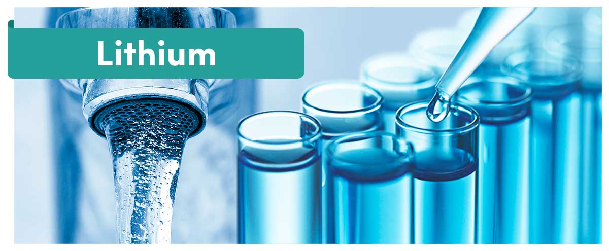 „Lithium“ als Schriftzug, im Hintergrund ein Wasserhahn und Pipette über gefüllten Reagenzgläsern