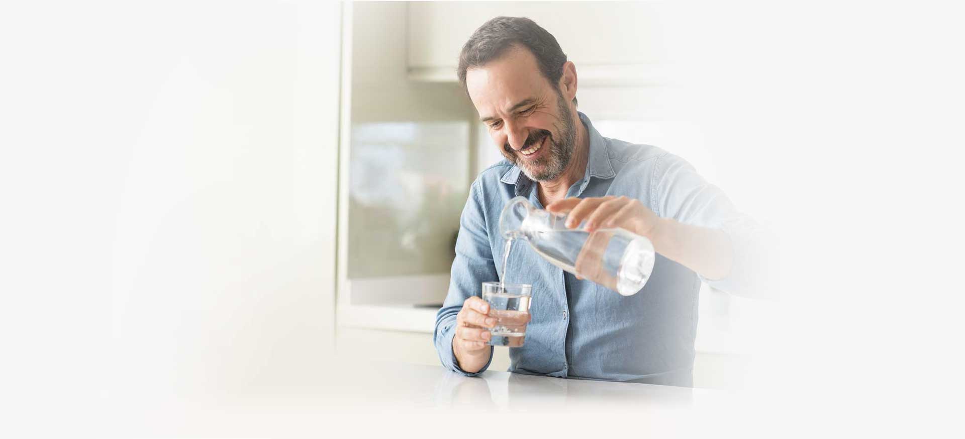 Mann genießt Wasser aus Trinkwasserfilteranlage