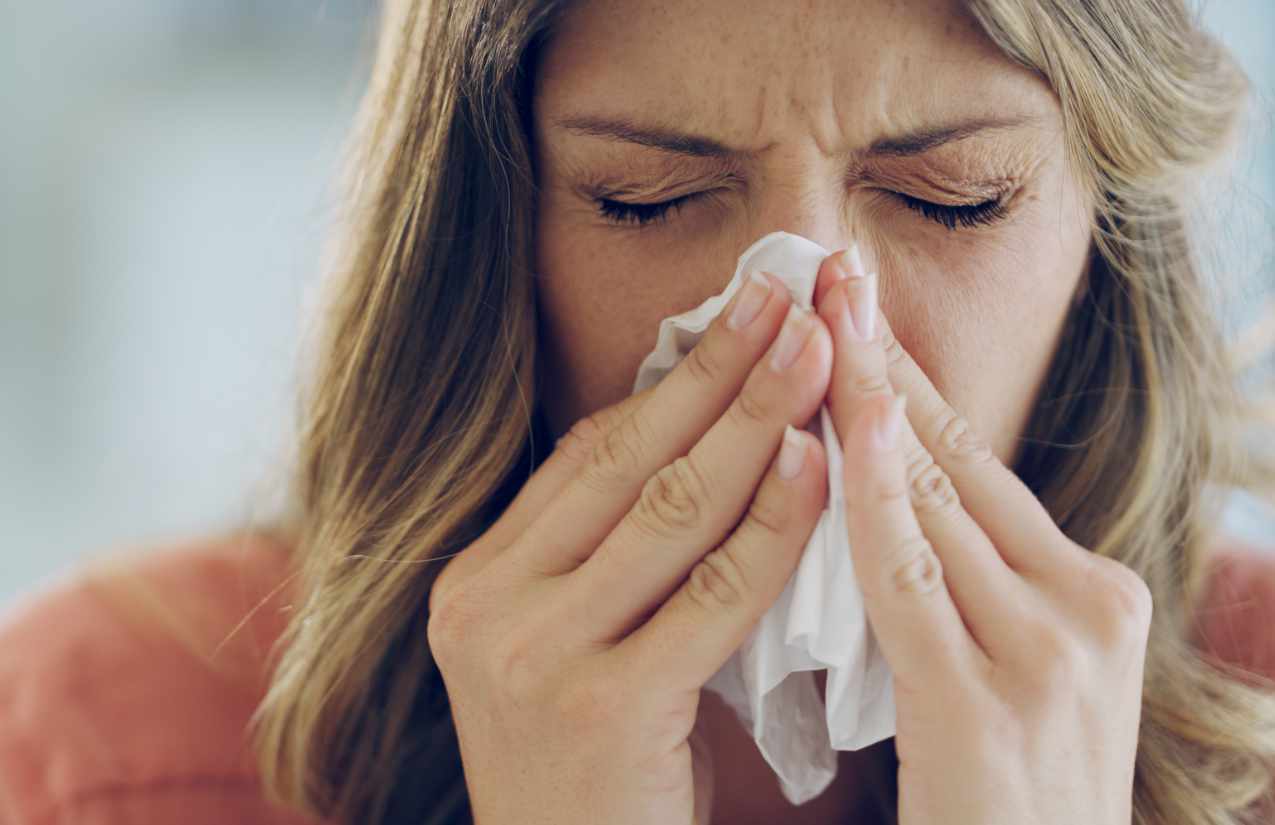 Viele Menschen mit Hausstauballergie leiden unter Symptomen wie Niesen oder einer verstopften Nase. @Cecilie_Arcurs /istockphoto.com