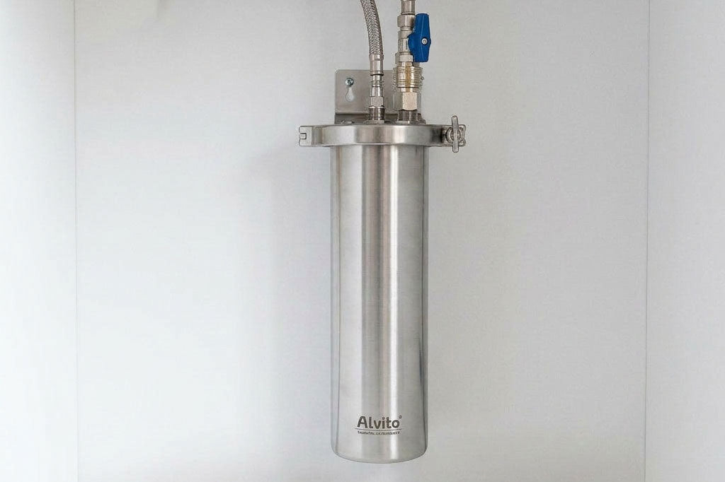 Alvito Edelstahl-Wasserfilter ohne Plastik an Wand montiert mit blauem Absperrventil und Metallanschlüssen