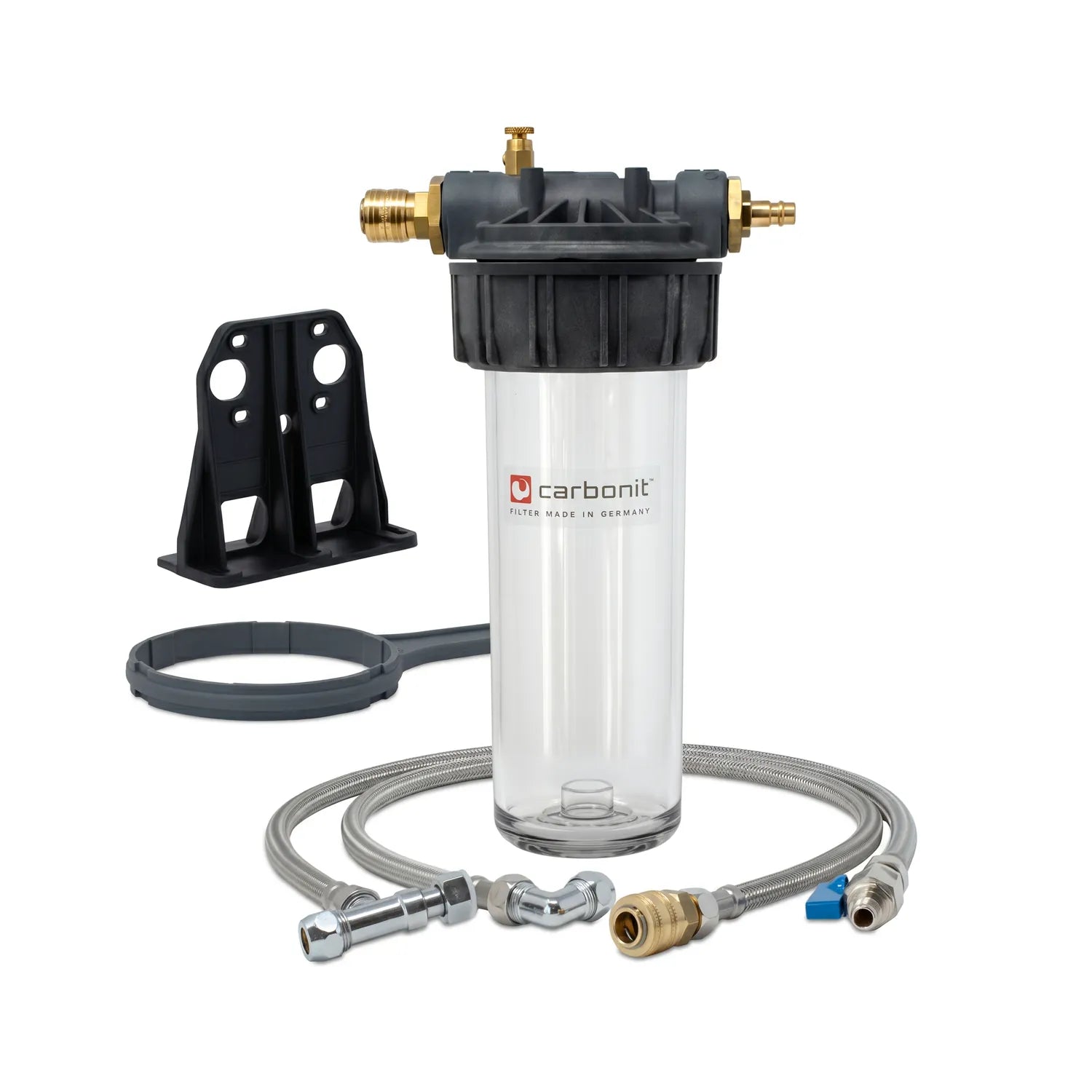 Carbonit Vario Basic Einbaufilter-Set freigestellt – transparentes Filtergehäuse (leer) mit schwarzem Kopf und Messing-Schnellkupplungen, schwarzer Wandhalterung, grauer Ringschlüssel, Edelstahlschlauch mit Anschlussfittings; weißer Hintergrund
