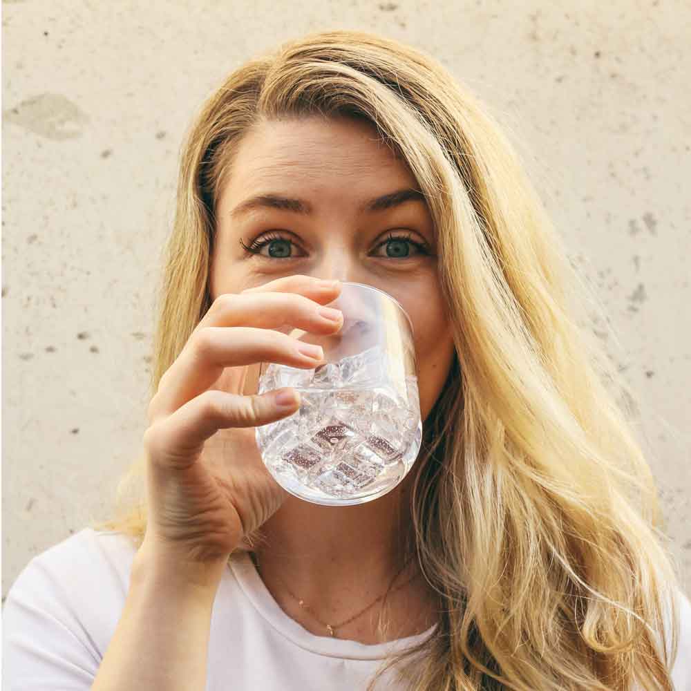 glückliche Frau trinkt Wasser